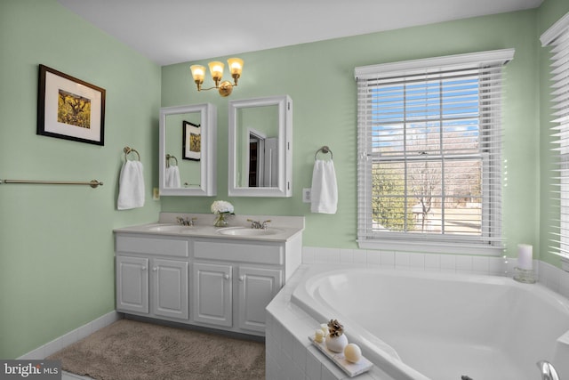 full bath with a sink, a chandelier, a bath, and double vanity