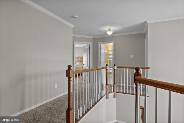 corridor with baseboards, an upstairs landing, carpet floors, and ornamental molding