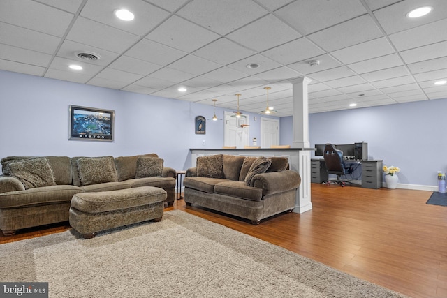 living area with wood finished floors, visible vents, baseboards, recessed lighting, and a drop ceiling