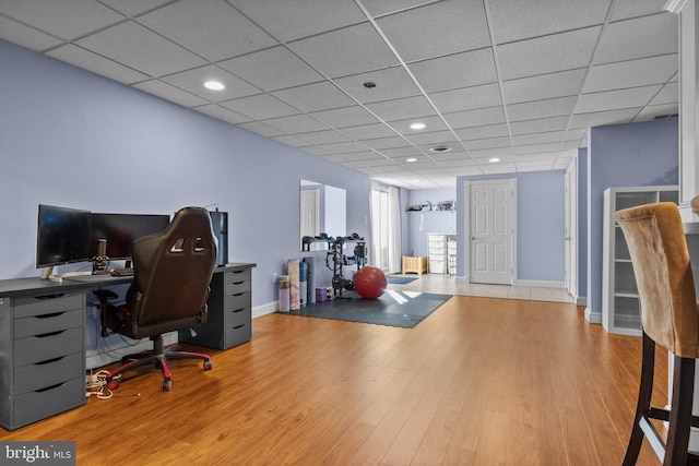 office area with a drop ceiling, baseboards, and wood finished floors