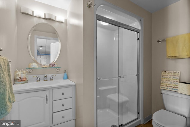 full bathroom featuring a shower stall, toilet, and vanity