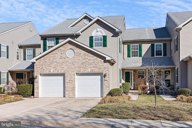 traditional-style home with a garage, brick siding, concrete driveway, and a shingled roof