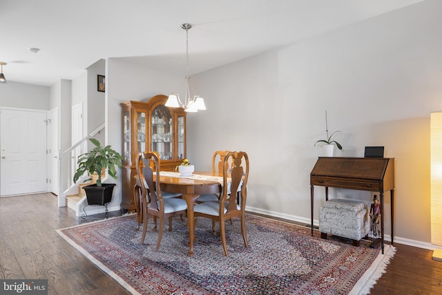 dining room featuring a chandelier, stairway, baseboards, and wood finished floors