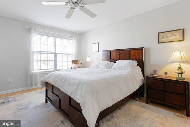 bedroom with baseboards, light wood finished floors, and ceiling fan