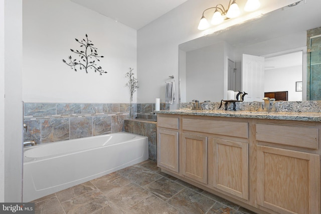 full bathroom featuring double vanity, a bath, and a sink