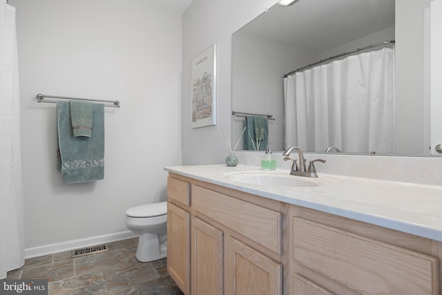 full bathroom with vanity, baseboards, visible vents, stone finish floor, and toilet