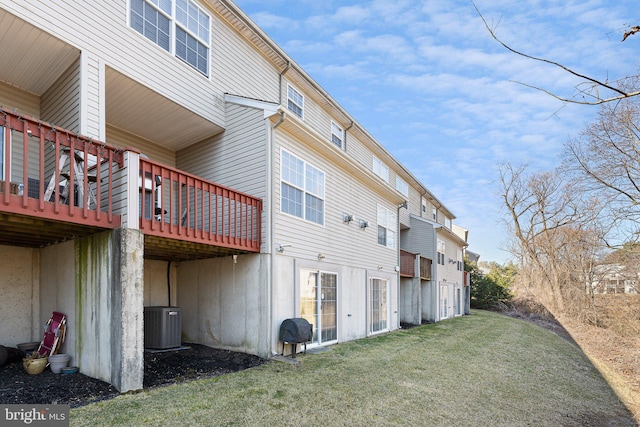 back of house featuring a yard, a wooden deck, and cooling unit