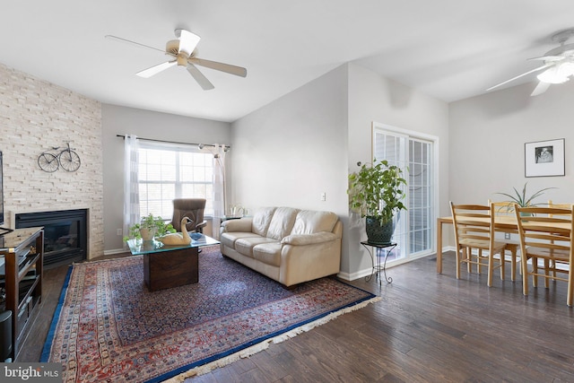 living room with a brick fireplace, baseboards, a ceiling fan, and wood finished floors