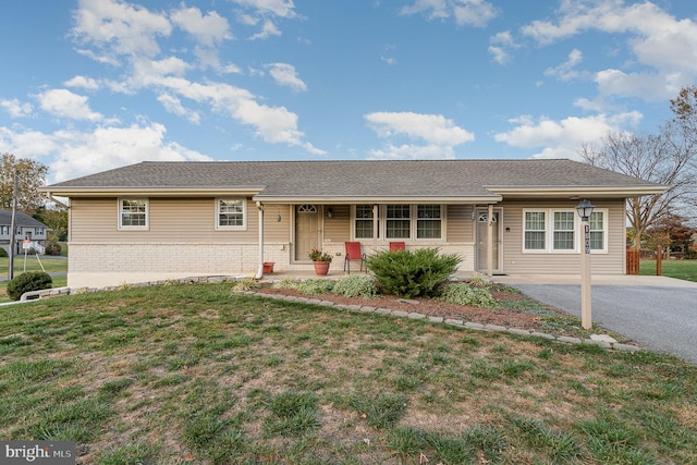 ranch-style home with a front lawn, a porch, brick siding, and driveway