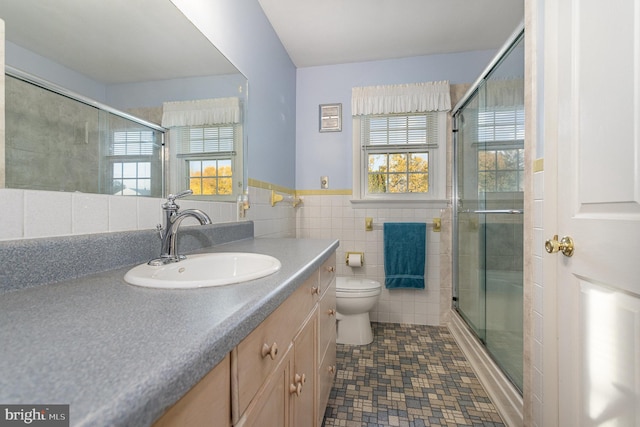 full bath featuring tile walls, toilet, a healthy amount of sunlight, and a stall shower