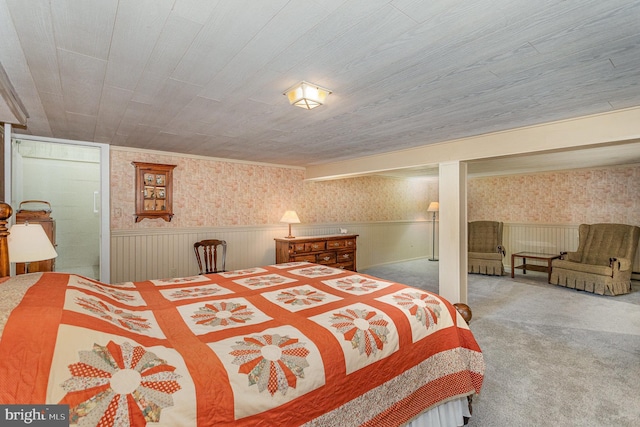 carpeted bedroom featuring a wainscoted wall and wallpapered walls