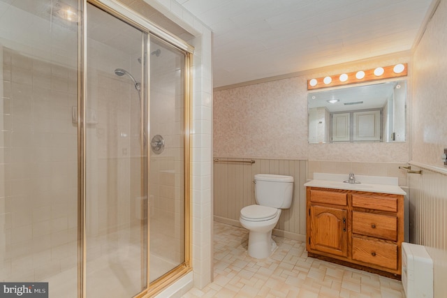 full bathroom with toilet, a shower stall, wainscoting, and wallpapered walls