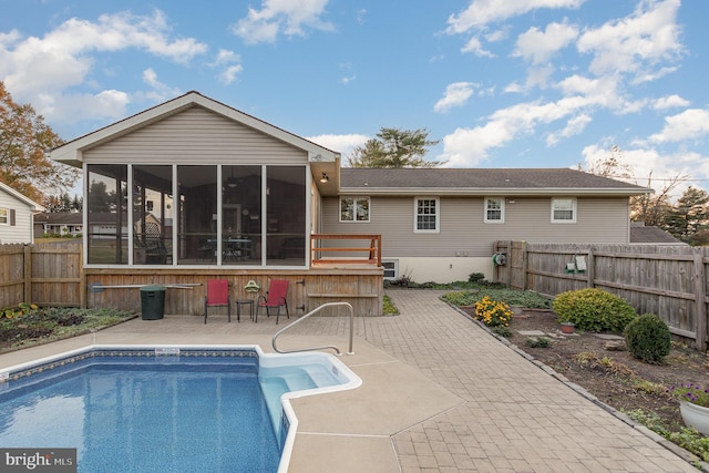 back of house with a patio, a fenced backyard, a fenced in pool, and a sunroom