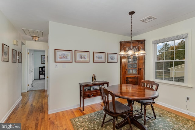 dining room with baseboards, visible vents, and light wood finished floors