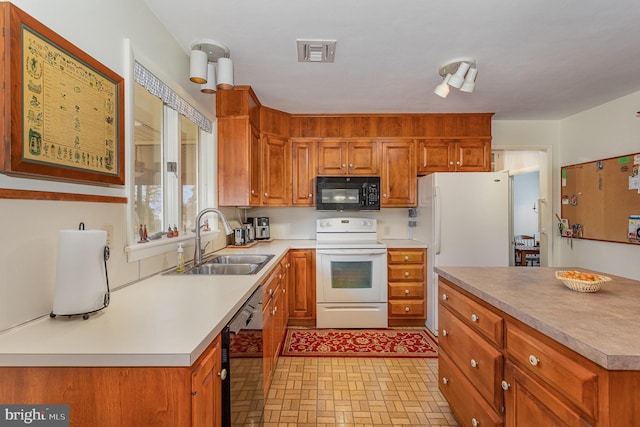 kitchen featuring a sink, visible vents, brown cabinets, and black appliances