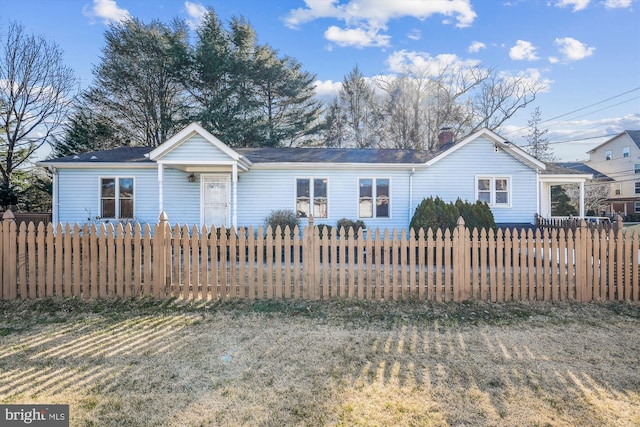 view of front of home with a fenced front yard and a chimney