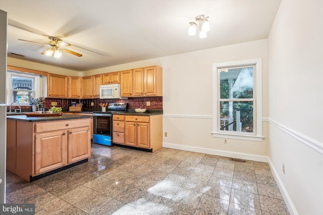 kitchen with granite finish floor, white microwave, baseboards, and range with electric stovetop