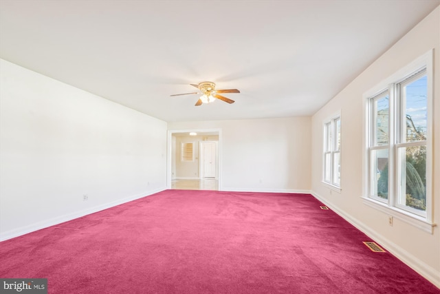 empty room with carpet flooring, baseboards, visible vents, and ceiling fan