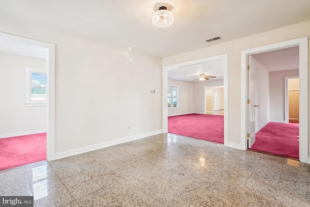 spare room featuring visible vents, baseboards, and granite finish floor