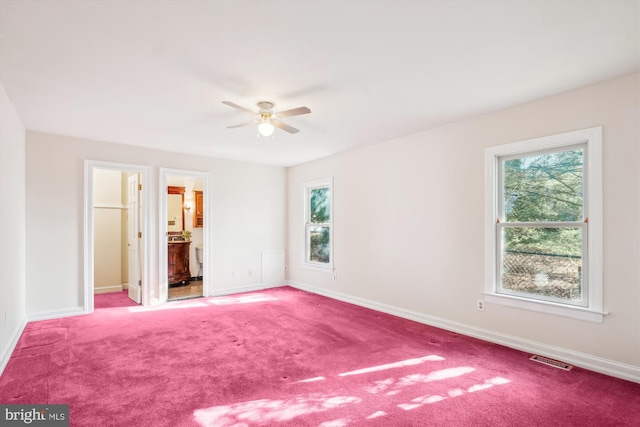 unfurnished bedroom featuring visible vents, connected bathroom, baseboards, and carpet