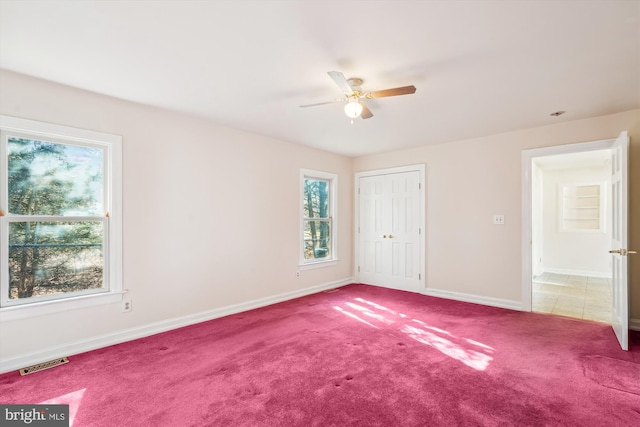 unfurnished bedroom with a ceiling fan, baseboards, visible vents, carpet floors, and a closet