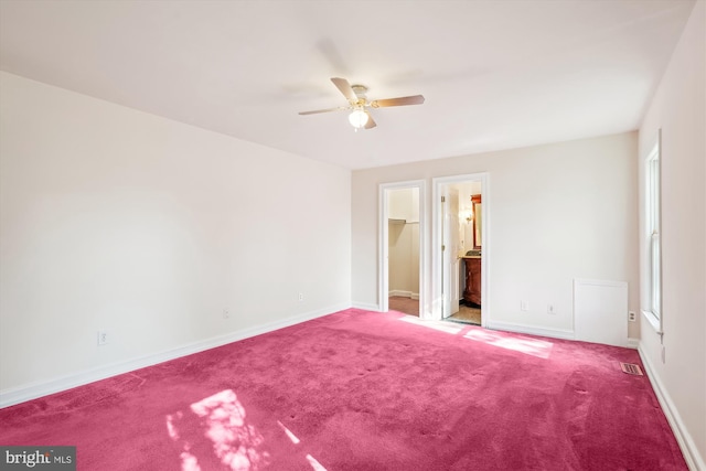 unfurnished bedroom featuring a spacious closet, carpet flooring, visible vents, and baseboards