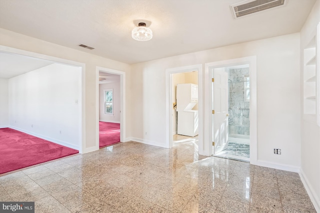 unfurnished room featuring granite finish floor, visible vents, and baseboards