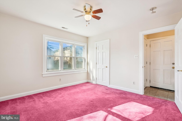 unfurnished bedroom featuring visible vents, carpet flooring, baseboards, and ceiling fan