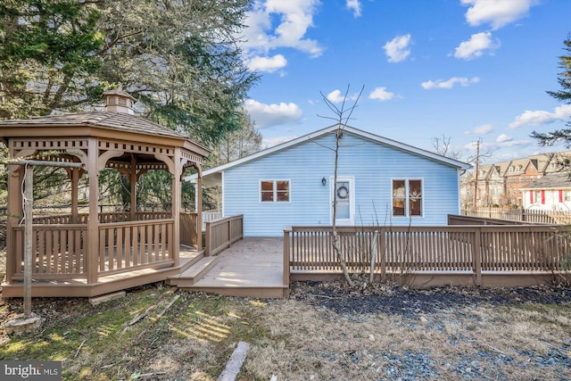 rear view of house featuring a deck and a gazebo