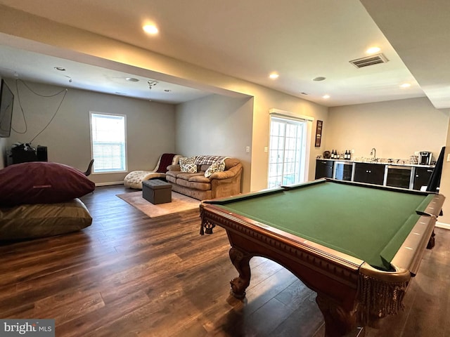 recreation room with visible vents, dark wood-type flooring, baseboards, indoor wet bar, and recessed lighting