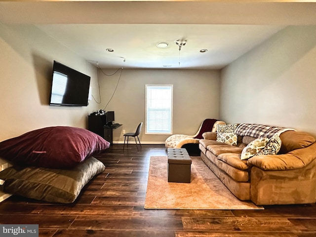 living area with baseboards and wood finished floors