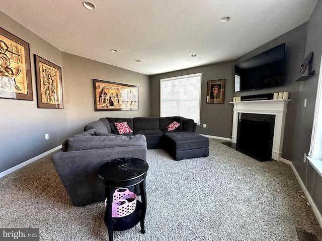 carpeted living area with recessed lighting, a fireplace with flush hearth, baseboards, and visible vents