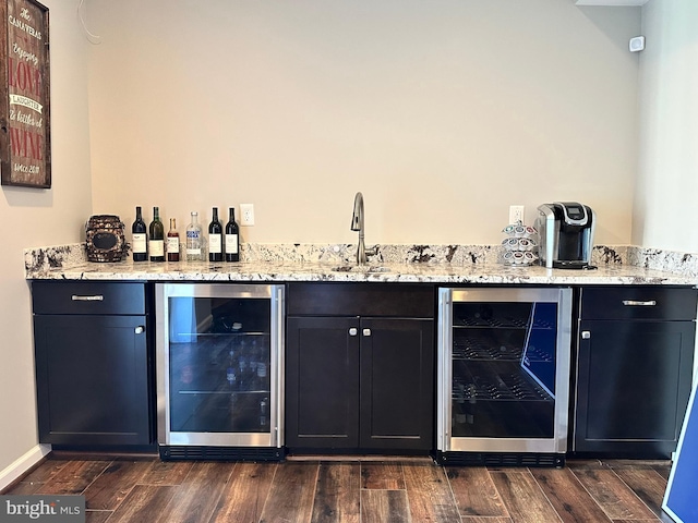 bar with beverage cooler, a sink, wet bar, and dark wood-style flooring