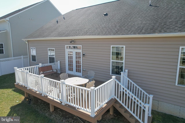 wooden deck with a lawn, french doors, and fence