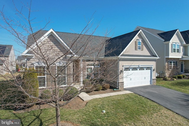 view of front facade with aphalt driveway, a front yard, and a shingled roof