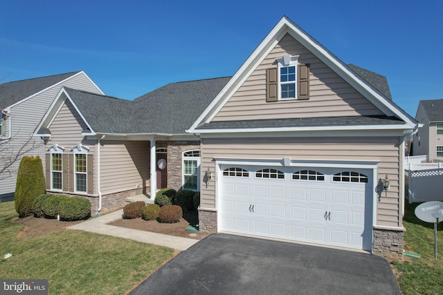 view of front facade featuring an attached garage, stone siding, and driveway