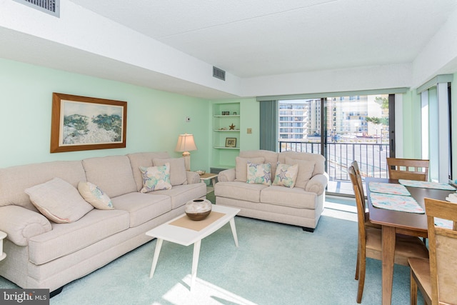 living area featuring carpet flooring, built in features, and visible vents