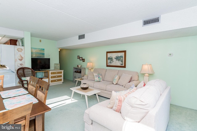 carpeted living area featuring visible vents and a textured ceiling