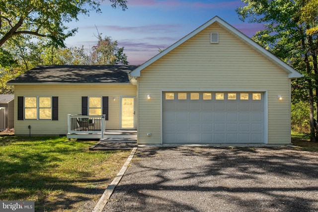 ranch-style house with a front lawn, a garage, driveway, and a wooden deck