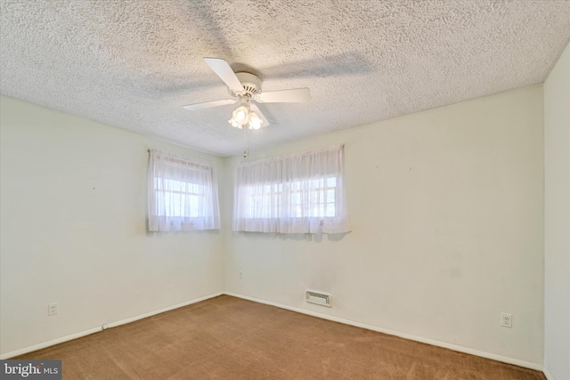 unfurnished room featuring visible vents, baseboards, carpet flooring, a textured ceiling, and a ceiling fan