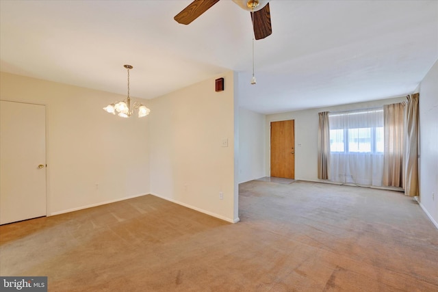 spare room featuring baseboards, light carpet, and ceiling fan with notable chandelier