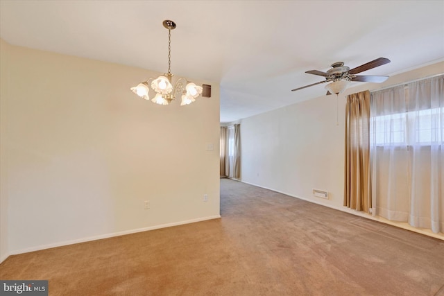 spare room with a healthy amount of sunlight, carpet flooring, and ceiling fan with notable chandelier