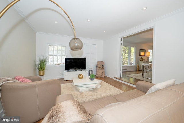 living area with recessed lighting, light wood-type flooring, baseboards, and ornamental molding