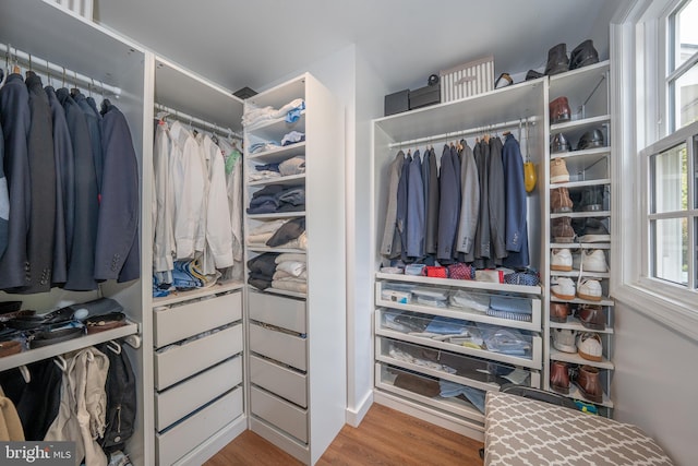 walk in closet with wood finished floors