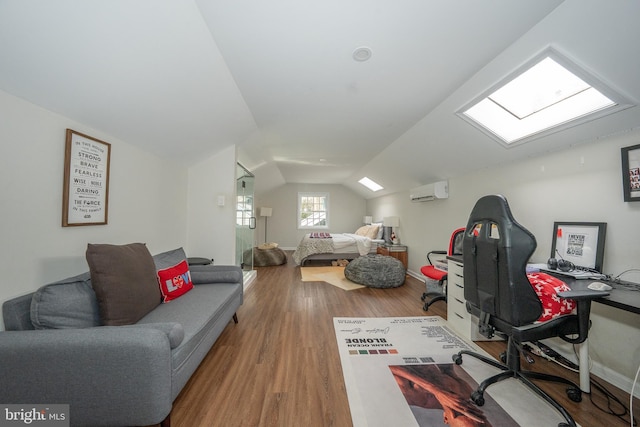 home office featuring baseboards, lofted ceiling with skylight, wood finished floors, and a wall mounted AC