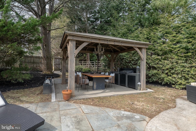 view of patio with a gazebo, outdoor dining area, and fence