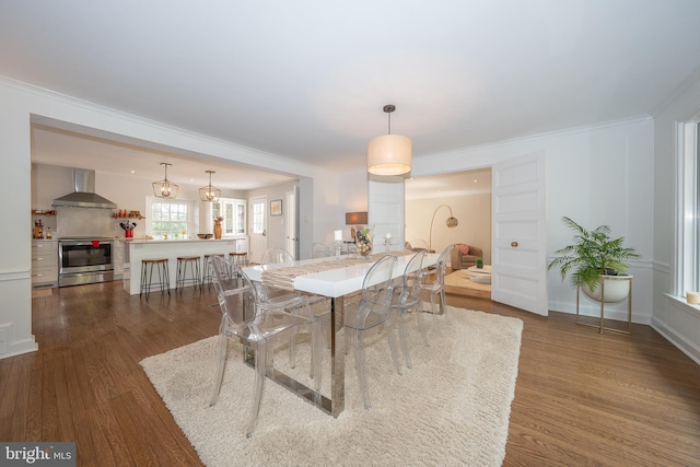 dining area featuring dark wood-type flooring, baseboards, and ornamental molding