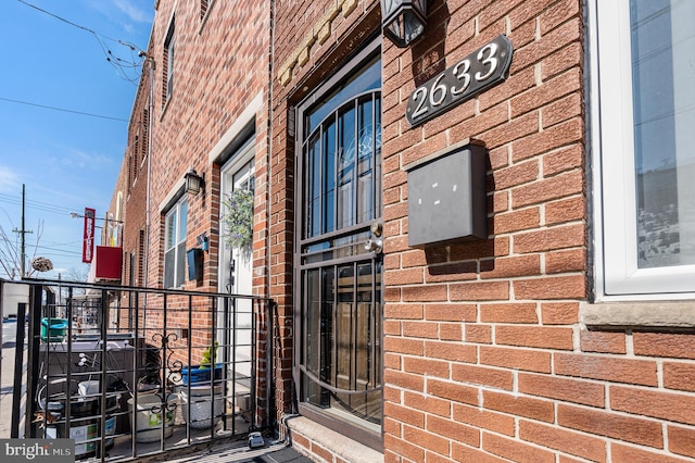 property entrance featuring brick siding