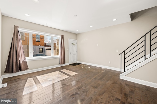 entryway featuring recessed lighting, baseboards, wood-type flooring, and stairs