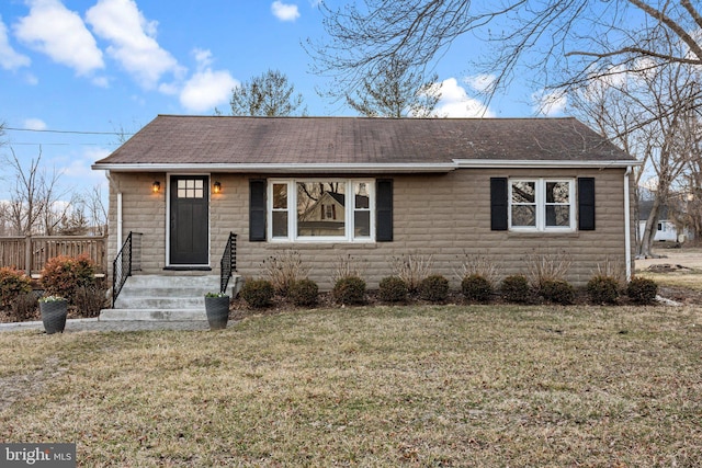 view of front of property featuring a front lawn and a shingled roof